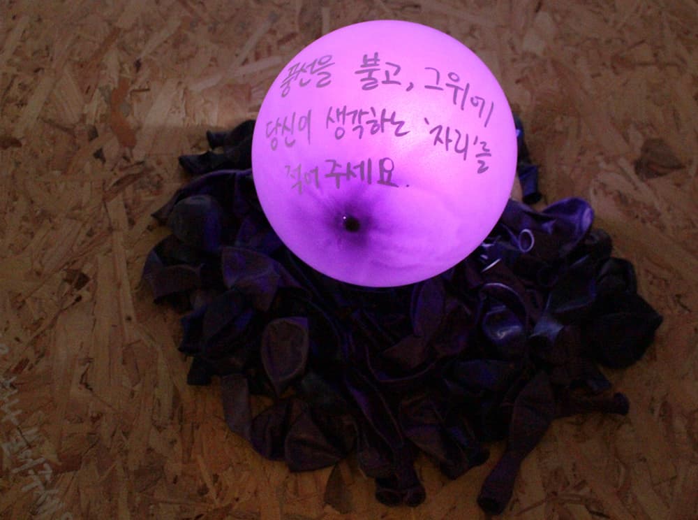 박민경 _ 자리를 위한 식탁 _ Balloon, Paint Pen, Wooden Table _ Dimensions Variable _ 2018