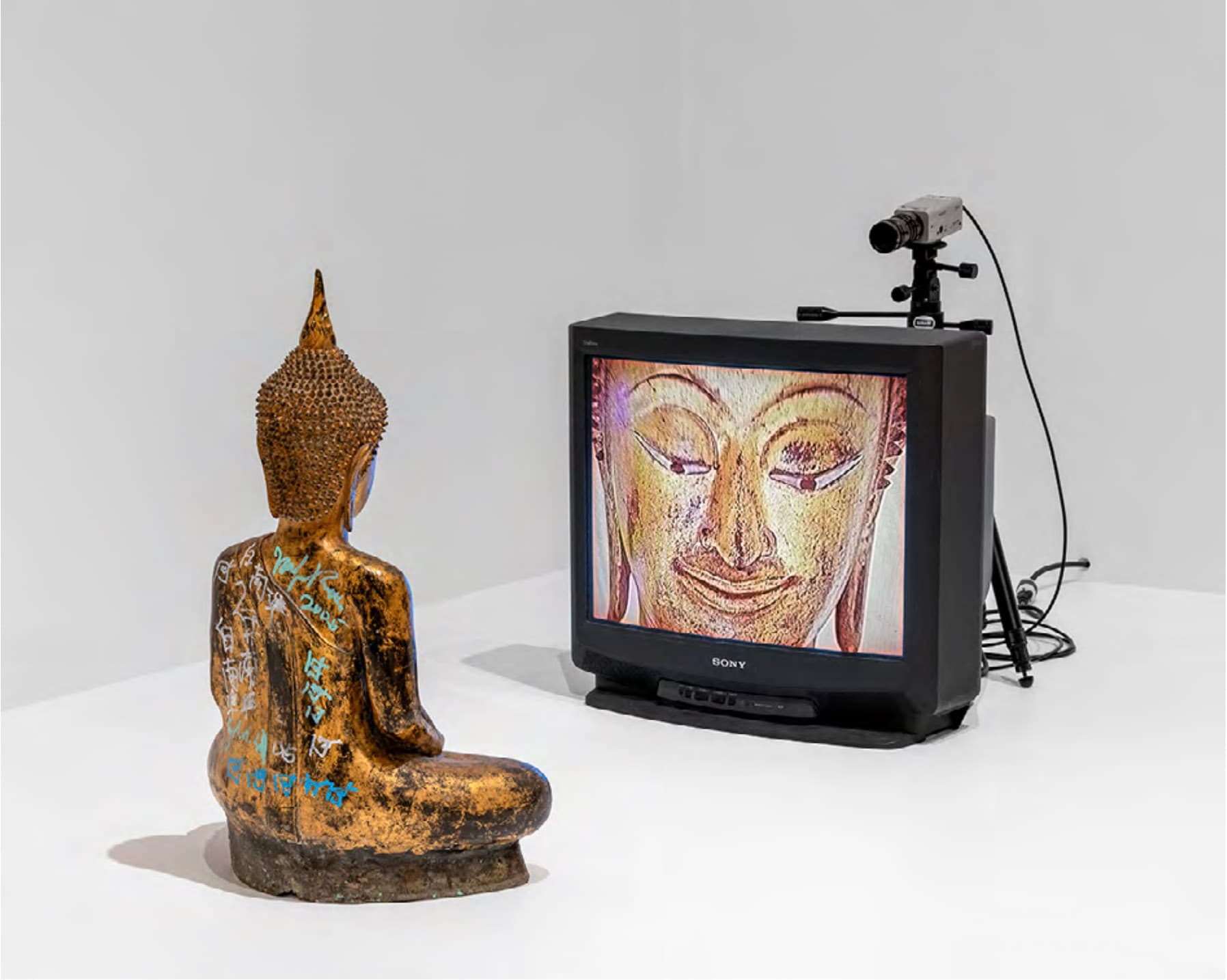 백남준, 〈골드 TV 부처(Gold TV Buddha)〉, 2005, 폐회로 비디오(컬러, 무음), 27인치 모니터, 비디오 카메라, 삼각대, 케이블, 금도금 청동 불상 위에 유성 마커, 80 × 66 × 215.9 cm © Nam June Paik Estate. 사진: Paula Abreu Pita, Brooklyn Museum